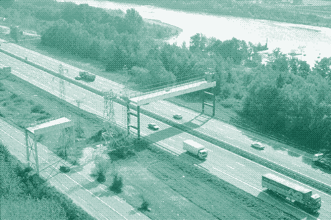 Image: a modern ropeway crosses a highway.