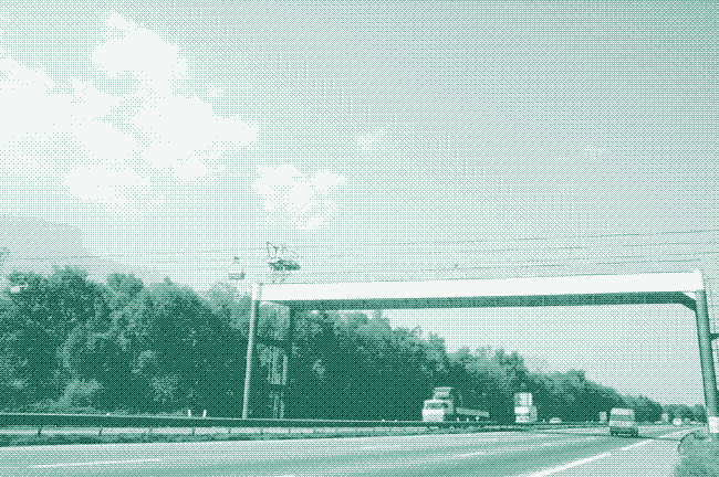 Image: a modern ropeway crosses a highway.