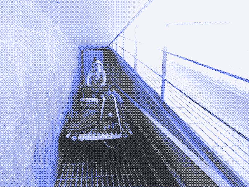 Image: Kozimo pushes the handcart through a narrow walkway. Photo by Kris De Decker.